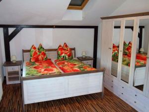 a bedroom with two beds with red and green pillows at Landferienhaus Havelland in Kloster Lehnin in Trechwitz