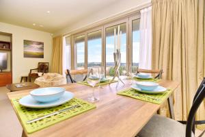 un comedor con una mesa de madera con gafas. en High Country Villa 238 - Terrace Downs Resort, en Windwhistle