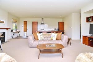 una sala de estar con un sofá y una mesa en High Country Villa 238 - Terrace Downs Resort, en Windwhistle