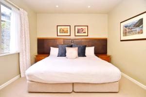 a bedroom with a large white bed with a window at High Country Villa 238 - Terrace Downs Resort in Windwhistle