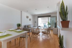 een keuken en een woonkamer met een tafel en stoelen bij Apartamento Frentemar 2 - Costa CarpeDiem in Calpe
