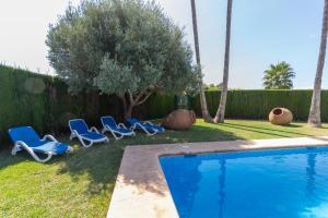 - un groupe de chaises longues à côté de la piscine dans l'établissement Villa Benimarco - Costa CarpeDiem, à Teulada