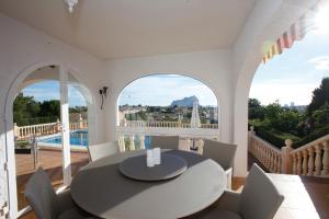 uma sala de jantar com uma mesa e cadeiras numa varanda em Villa Robin - Costa CarpeDiem em Calpe