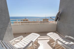 a balcony with two chairs and a view of the ocean at Apartamento Apolo XIV - Costa CarpeDiem in Calpe