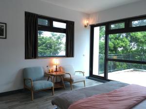 1 dormitorio con 1 cama, mesa y sillas en Greenville Maioli, en Tongxiao