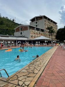 un gruppo di persone in una piscina in un hotel di Hotel Cavalinho Branco Flat-105 ad Águas de Lindóia