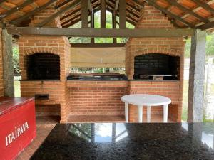 un forno di mattoni con un tavolo bianco davanti di Hotel Cavalinho Branco Flat-105 ad Águas de Lindóia
