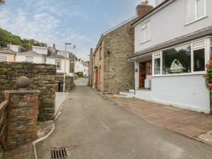 een straat in een dorp met een stenen gebouw bij Anchor Cottage in Salcombe
