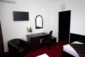 a room with a desk and a bed and a mirror at Hotel Terra in Oradea