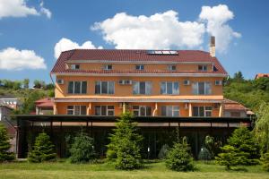 a large orange building with a red roof at Hotel Terra in Oradea