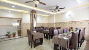格德拉Hotel The Vaishno Devi Hills的一间带桌椅和吊扇的用餐室