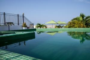 uma piscina de água com árvores e guarda-sóis em Hotel Monterrey em Cartagena de Indias