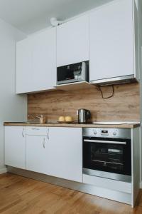 a kitchen with white cabinets and a microwave at Residential Barona Apartments in Riga Centre in Rīga