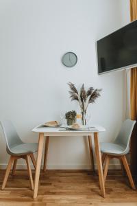 a table with two chairs and a tv on a wall at Residential Barona Apartments in Riga Centre in Rīga
