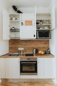 cocina con armarios blancos y fogones en Residential Barona Apartments in Riga Centre, en Riga