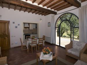 uma sala de estar com uma mesa e cadeiras e uma porta aberta em Belvilla by OYO Forno em Castelnuovo Berardenga