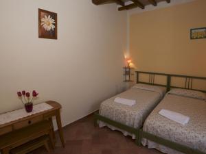 um quarto com duas camas e uma mesa com flores em Belvilla by OYO Forno em Castelnuovo Berardenga