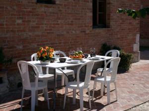 uma mesa branca e cadeiras com frutas e flores em Belvilla by OYO Forno em Castelnuovo Berardenga