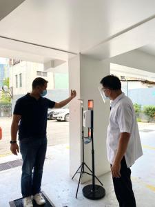 two men wearing masks standing next to a building at iHotel Uptown BGC in Manila