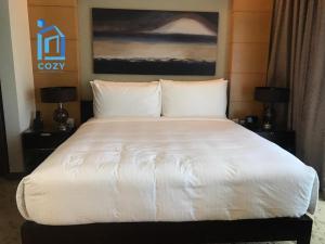 a bed with white sheets and pillows in a room at The Address Dubai Mall Residence-Burj Khalifa View 2 in Dubai