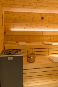 a sauna with a stove and a wooden wall at Hotel Alpin Tyrol - Kitzbüheler Alpen in Sankt Johann in Tirol