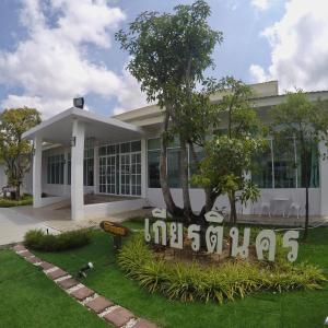 ein weißes Gebäude mit einem Schild davor in der Unterkunft โรงแรมเกียรตินคร (Kiatnakhon Hotel) in Nakhon Si Thammarat