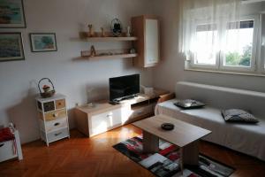 - un salon avec un canapé et une télévision dans l'établissement Spacious 2-room apartment with beautiful sea view, à Crikvenica