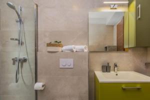 a bathroom with a shower and a sink and a mirror at Villa REANA in Brela