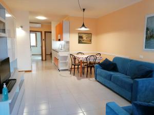 a living room with a blue couch and a table at Appartamento con 2 terrazze Porto Azzurro a 300 mt dal centro in Porto Azzurro