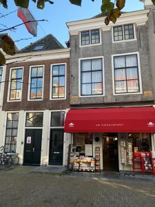 um edifício com um toldo vermelho numa rua em De Maecht van Mechelen em Zierikzee