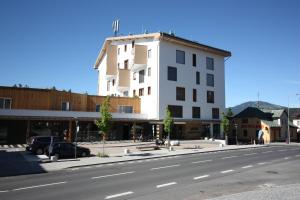 ein weißes Gebäude an der Straßenseite in der Unterkunft Rezidence Šumava in Železná Ruda