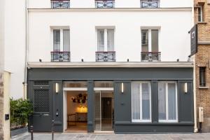 uma fachada de um edifício branco com uma entrada preta em HOTEL AU COEUR DES ARTS ET METIERS em Paris