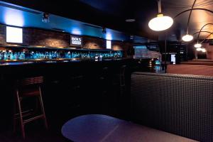 bar z niebieskimi światłami i stołkiem barowym w obiekcie Hotel Remes w mieście Opalenica +37 zdjęć