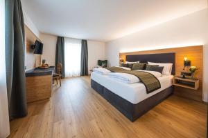 a hotel room with a large bed and a desk at Landgasthof Hubertus in Frauenau