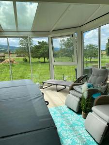 a screened in porch with couches and a table at Villa Spa de l’Ajoie in Cornol