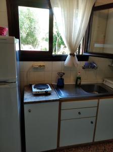 una pequeña cocina con fregadero y ventana en Dialiskari #2, en Limniónas