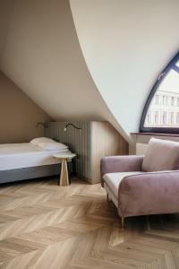 トルンにあるApartamenty Małe Garbaryのソファとベッドと窓のある部屋