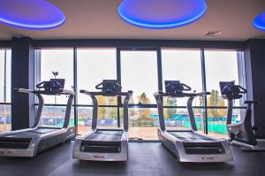 a gym with three treadmills in front of a window at Olympic Village in Podgortsy