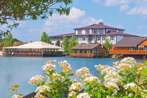 uma grande casa no lago com flores em Olympic Village em Podgortsy