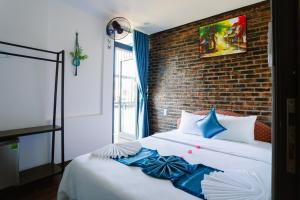 a bedroom with a bed with a brick wall at New World Hotel in Hue +53 photos