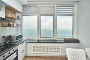 a kitchen with a large window with a view of the ocean at Board apart hotel in Odesa