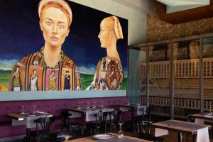 un restaurante con una gran pintura de una mujer en Hotel Vinícola Real-200 Monges, en Albelda de Iregua