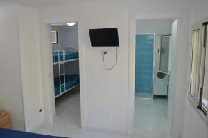 una camera ospedaliera con una TV appesa a un muro di DEPANDANCE SUL MARE a Sperlonga