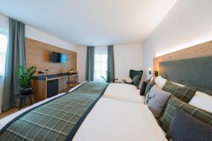 a hotel room with two beds and a desk at Landgasthof Hubertus in Frauenau