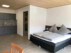 a bedroom with a large bed and a kitchen at Landgasthof Krone in Lauterach