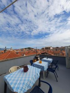 two tables on a balcony with a view of the city at Rooms Kisic in Dubrovnik