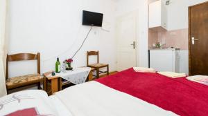 a bedroom with two beds and a table and a kitchen at Rooms Kisic in Dubrovnik