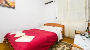 a bedroom with a red bed with towels on it at Rooms Kisic in Dubrovnik