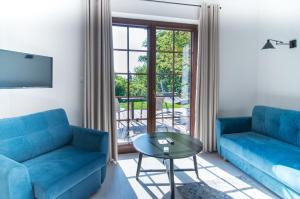 una sala de estar con 2 sofás azules y una mesa. en Kameralny domek Kazimierzówka en Kazimierz Dolny