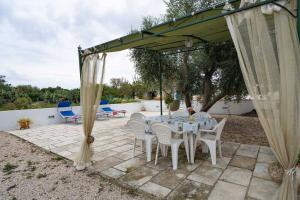 een tafel en stoelen onder een luifel op een patio bij VILLA TIMEA in Castrignano del Capo